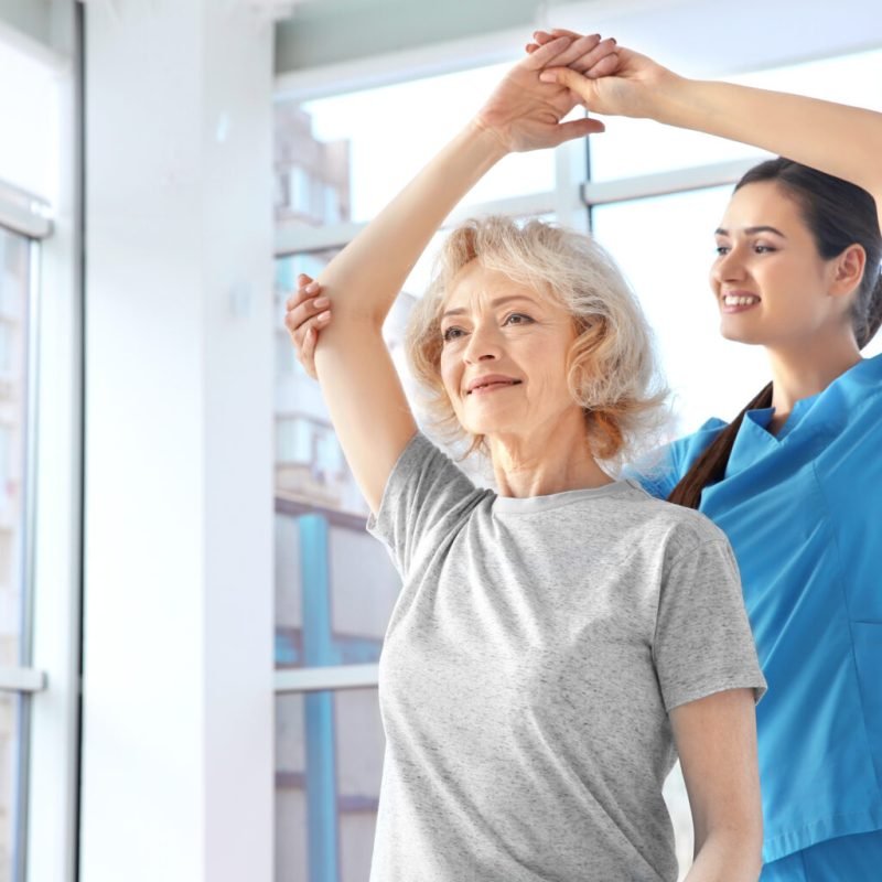 Physiotherapist working with elderly patient in clinic